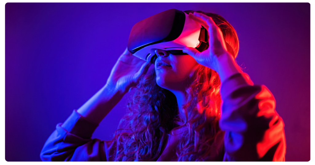 Mujer llevando y sujetando unas gafas de realidad virtual.